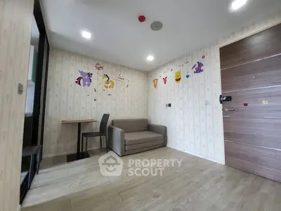 Cozy living room with modern decor and playful wall stickers, featuring a compact sofa and dining area.