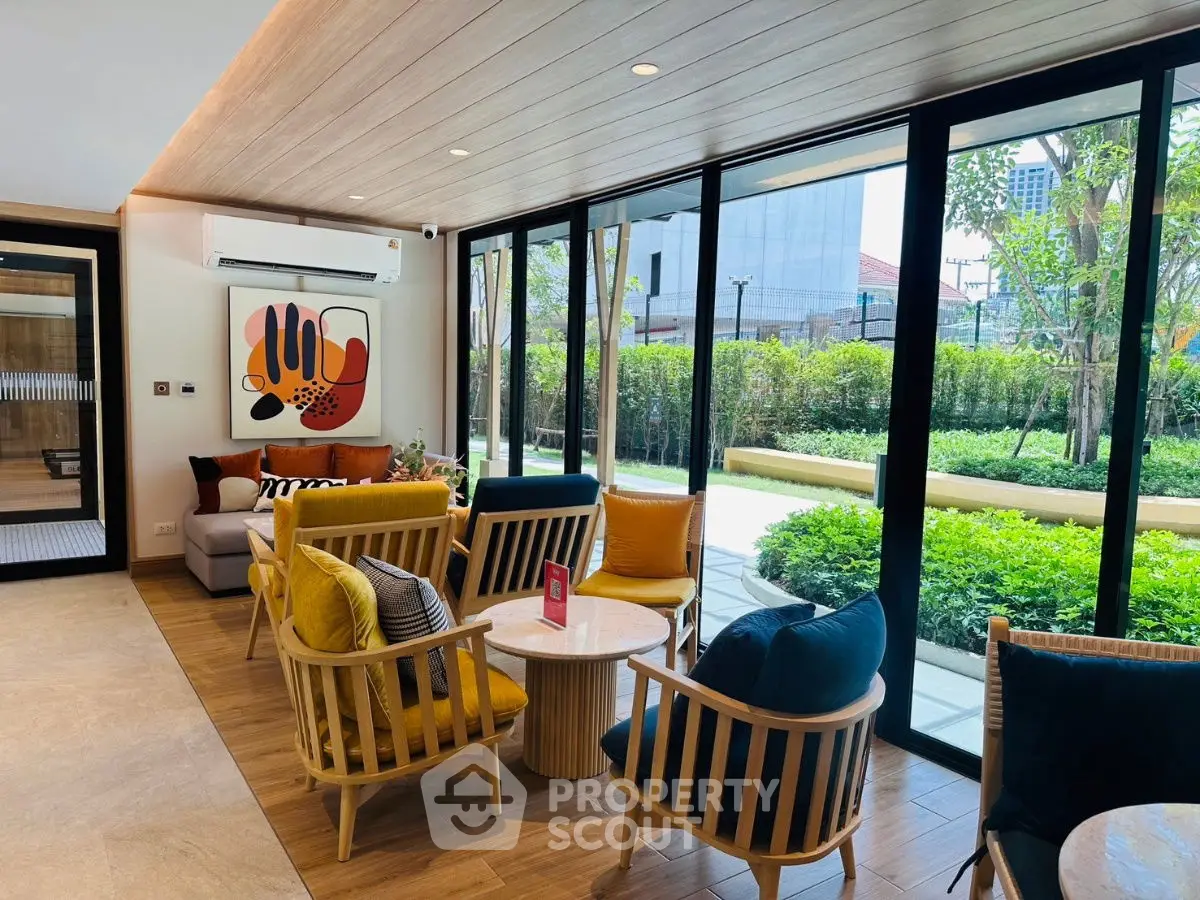 Stylish living room with modern decor and large windows overlooking lush garden.