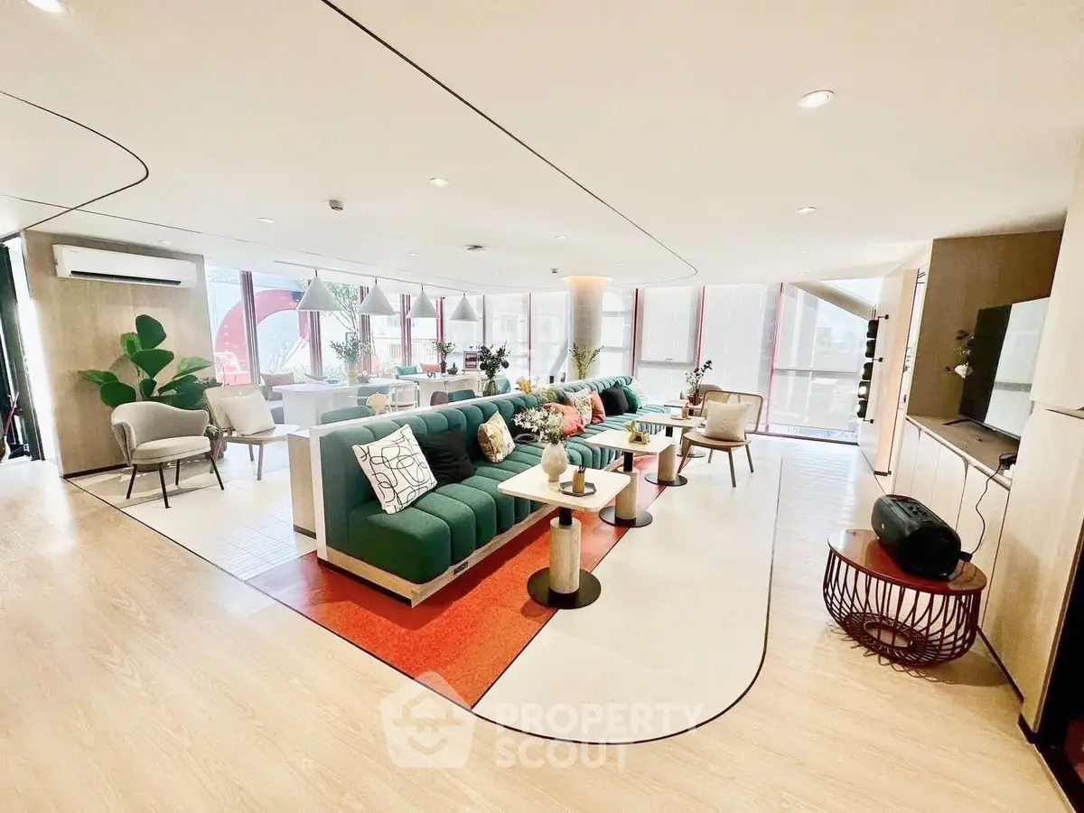 Spacious modern living room with stylish furniture and large windows offering abundant natural light.