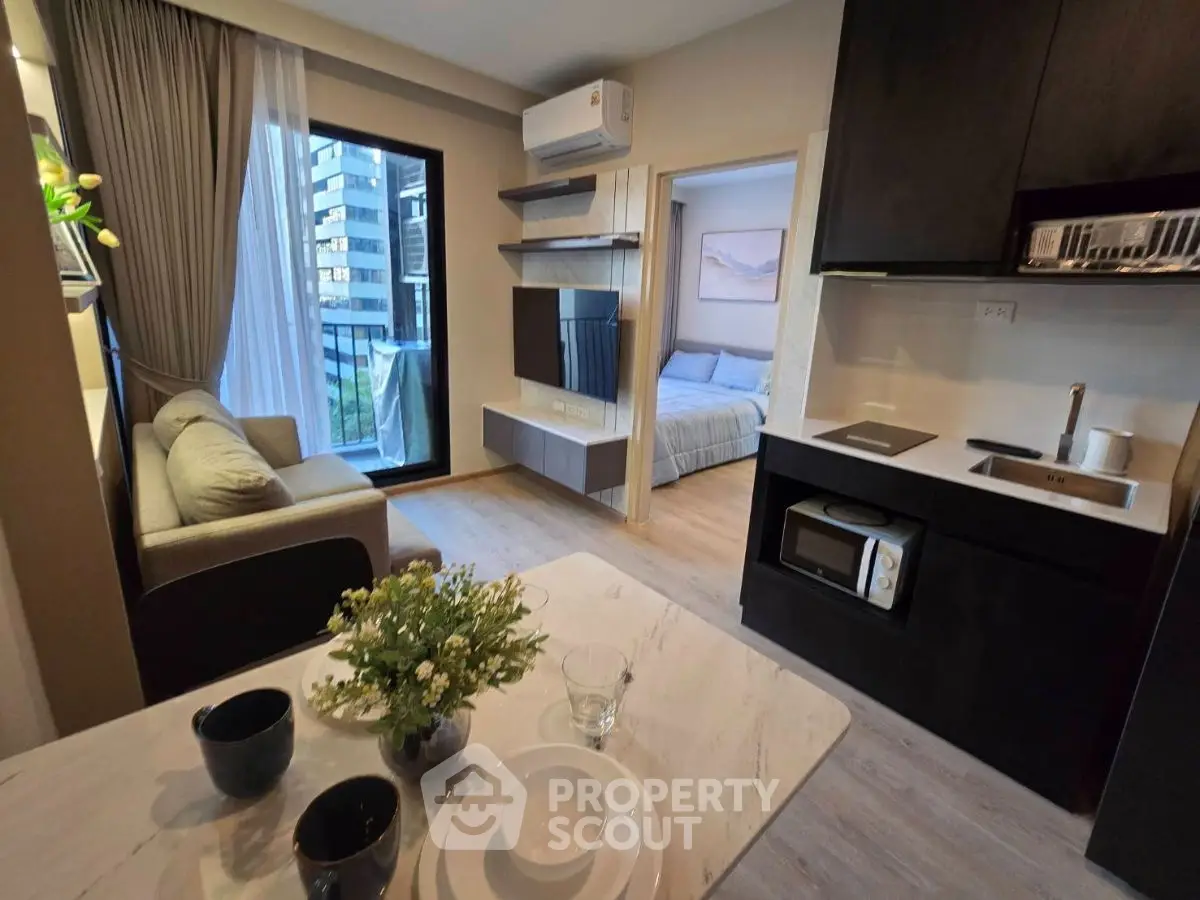Modern open-plan living room with kitchen and bedroom view in a stylish apartment