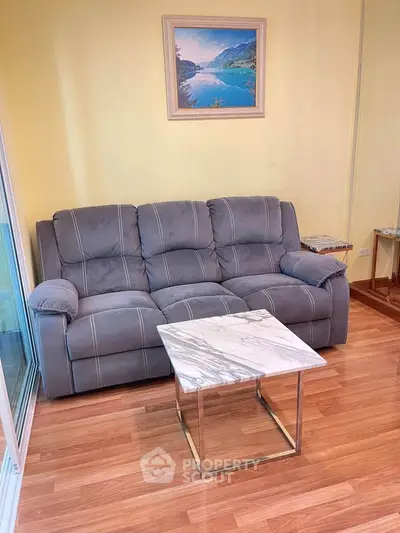 Cozy living room with plush gray sofa and elegant marble coffee table, perfect for relaxation.