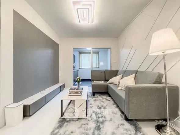 Modern living room with sleek gray sofa, stylish lighting, and contemporary decor.