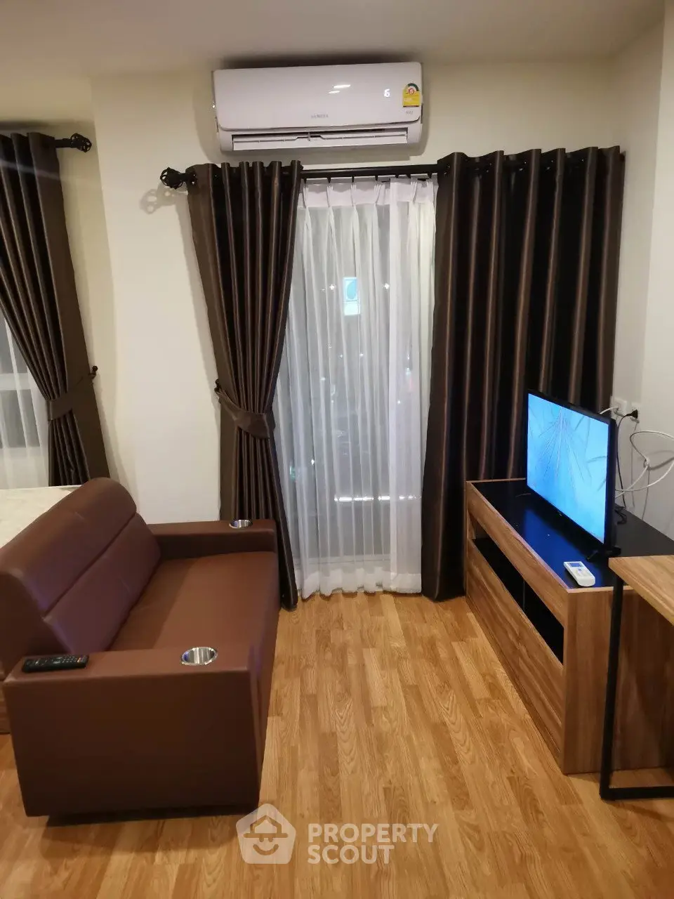 Cozy living room with modern furniture and air conditioning, perfect for relaxation.
