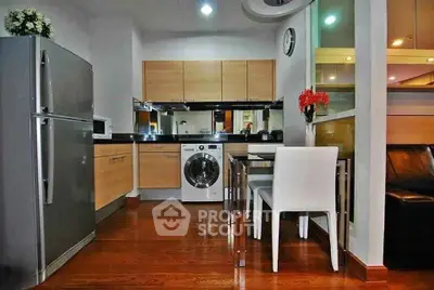 Modern kitchen with sleek appliances and wooden cabinetry in a stylish apartment.