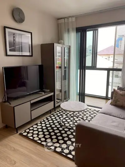 Modern living room with stylish decor and large window offering natural light.