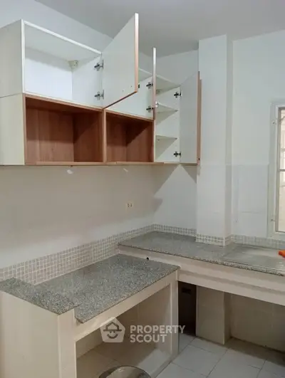 Modern kitchen with granite countertops and open cabinets in a stylish apartment