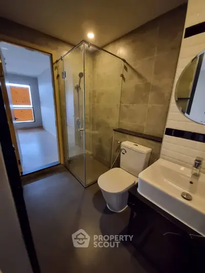 Modern bathroom with glass shower and sleek fixtures in a contemporary apartment.