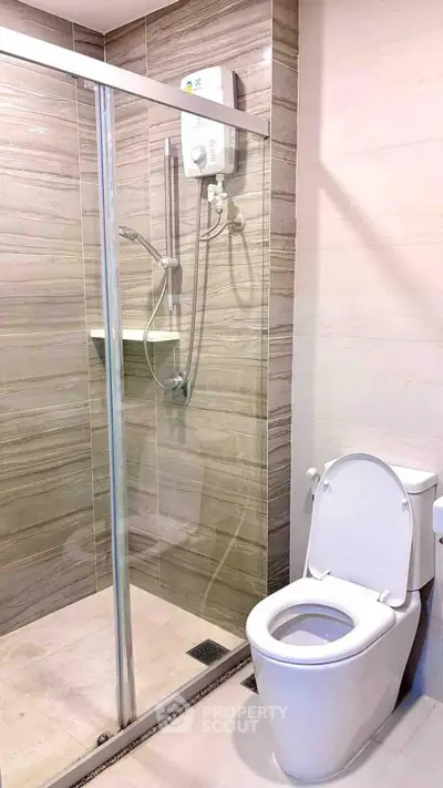 Modern bathroom with glass shower and sleek toilet design.