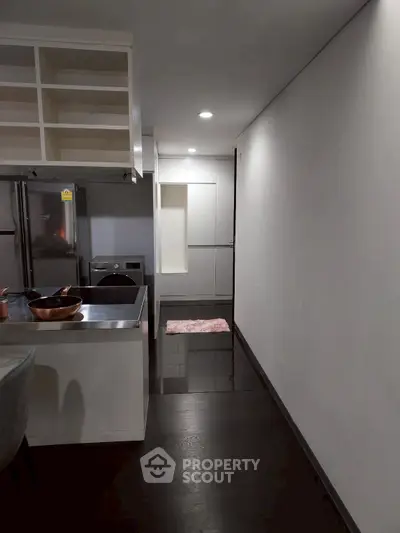 Modern kitchen with sleek appliances and open layout in contemporary apartment.