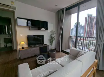 Modern living room with city view, featuring sleek furniture and large windows for natural light.
