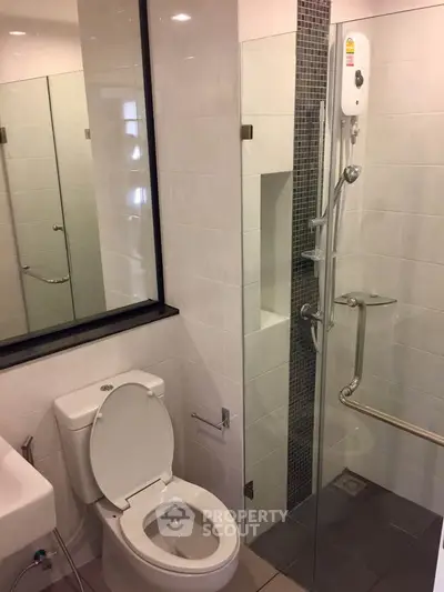 Modern bathroom with glass shower and sleek fixtures in a contemporary home.