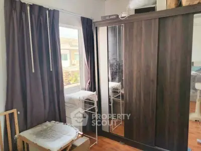 Cozy bedroom with mirrored wardrobe and window view, perfect for natural light lovers.