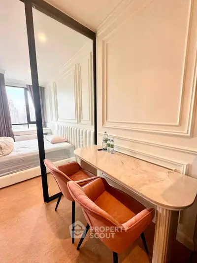 Luxurious bedroom with elegant marble desk and plush chairs, offering a serene city view.