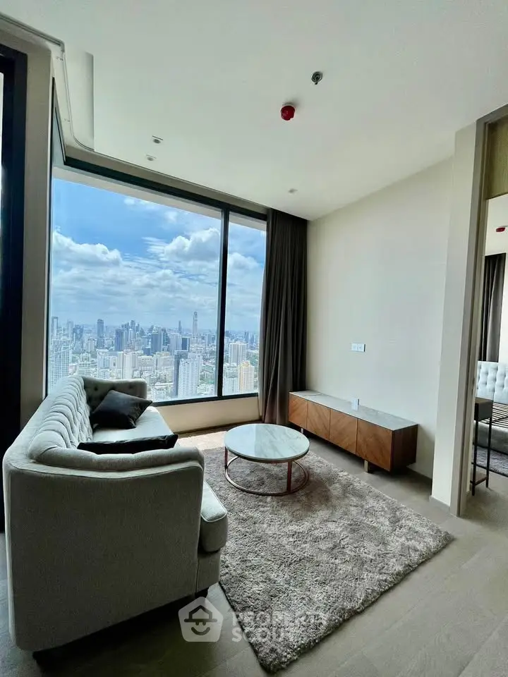 Luxurious living room with stunning city view, modern furniture, and large window in high-rise apartment.