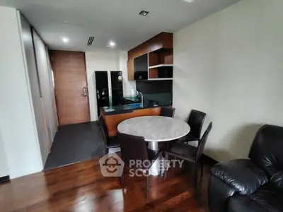 Modern apartment interior with open kitchen and dining area featuring sleek furniture.