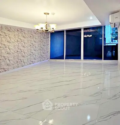 Spacious modern living room with elegant chandelier and marble flooring