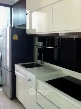 Modern kitchen with sleek cabinetry and stainless steel appliances in a contemporary apartment.