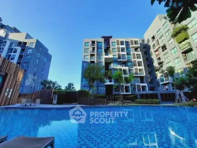 Modern condominium with stunning pool and lush greenery, perfect for luxury urban living.