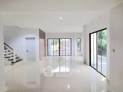 Spacious modern living room with large windows and glossy tile flooring