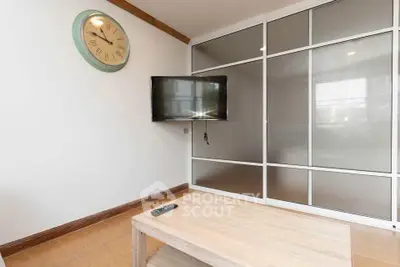 Modern living room with wall-mounted TV and stylish clock