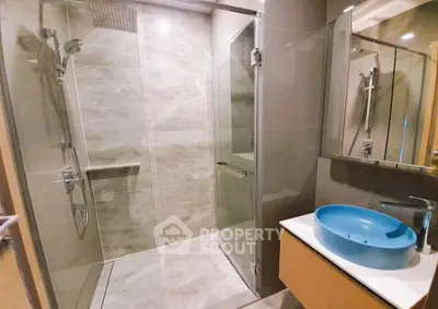 Modern bathroom with sleek shower and stylish blue basin