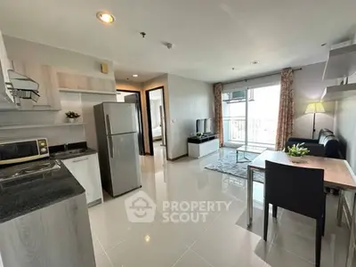 Modern open-plan living room and kitchen with sleek appliances and stylish decor.