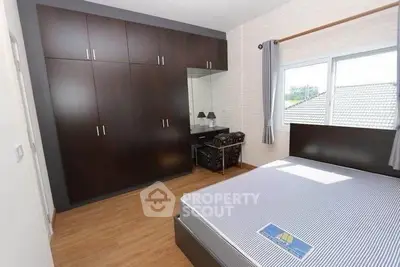 Spacious bedroom with large wardrobe and natural light in modern home.