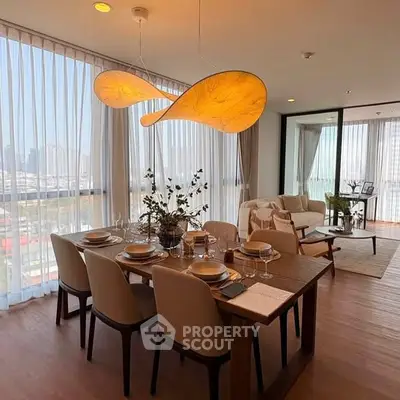 Elegant dining area with modern lighting and city view, perfect for entertaining guests.