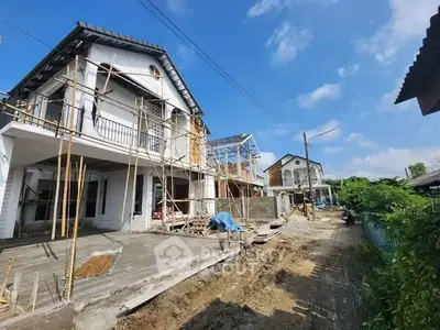 Newly constructed modern house with scaffolding on a sunny day, showcasing potential for customization.