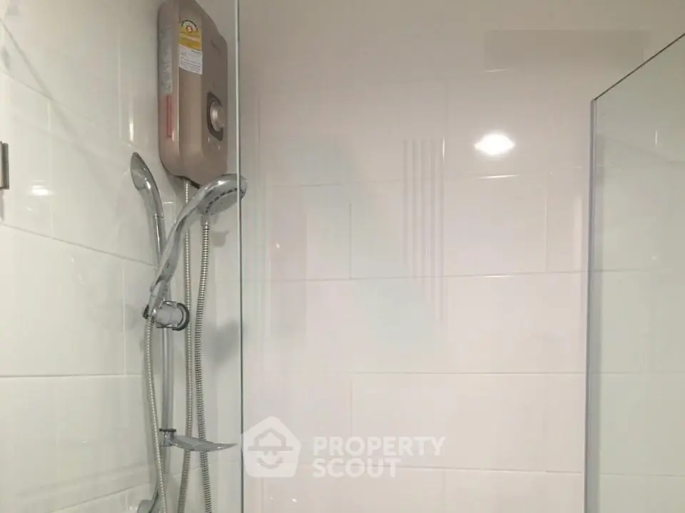 Modern bathroom with sleek shower fixtures and white tiled walls.