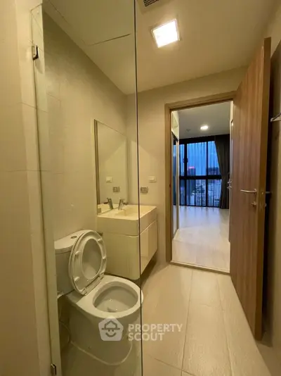 Modern bathroom with sleek design and glass partition in upscale apartment