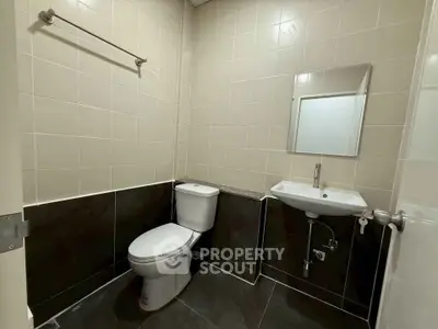 Modern bathroom with sleek tiles and compact fixtures, ideal for urban living.