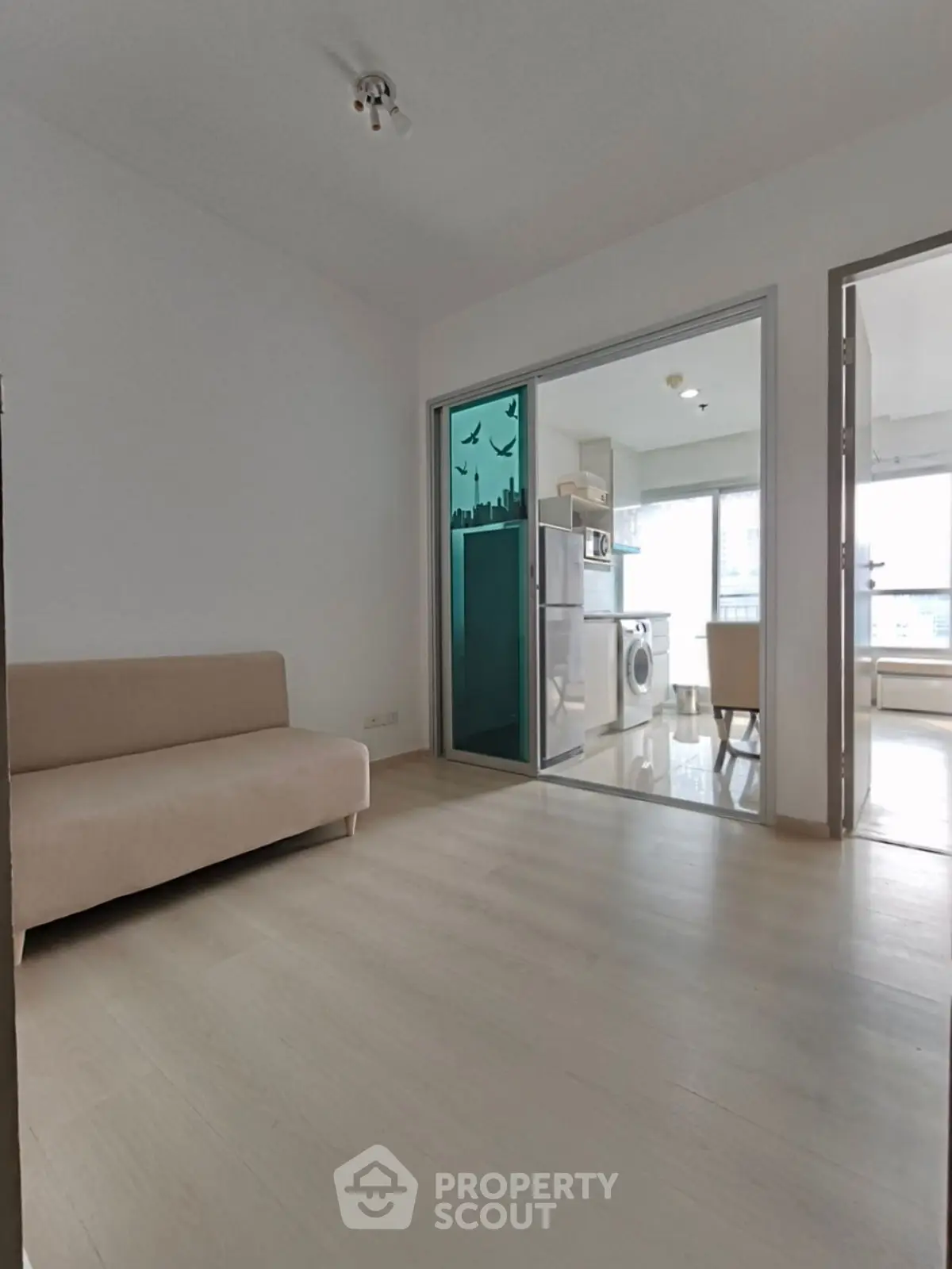 Modern apartment with open layout and stylish kitchen featuring washing machine and dining area.