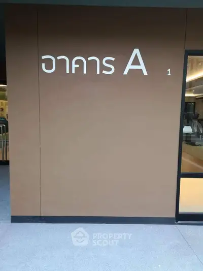 Modern building entrance with sleek design and clear signage, perfect for commercial or residential use.