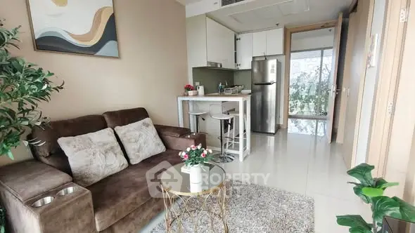 Modern living room with cozy sofa, stylish decor, and compact kitchen area in open layout apartment.