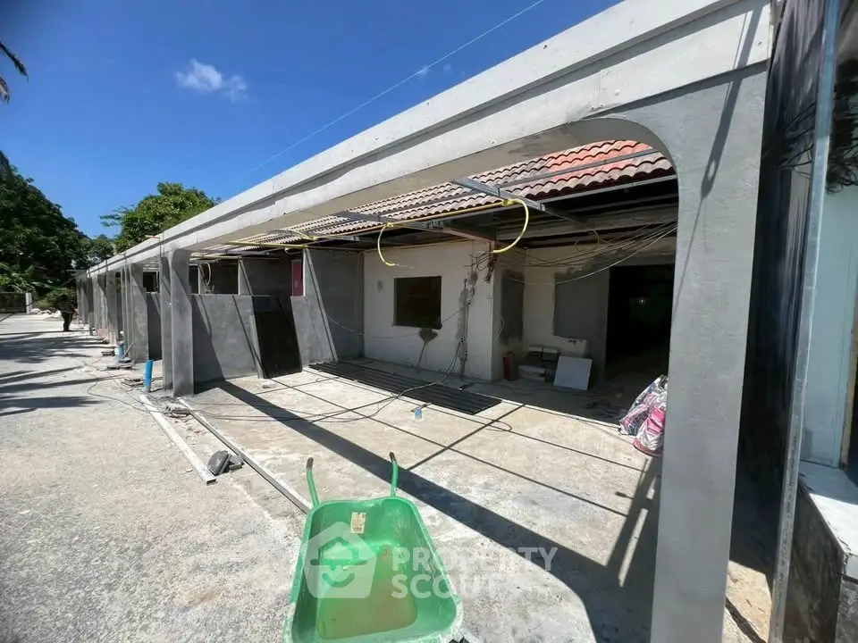 Under-construction building exterior with exposed wiring and materials, showcasing potential for renovation.