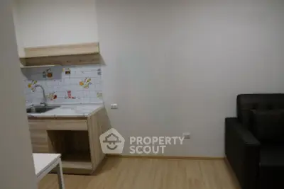 Cozy apartment interior with modern kitchenette and comfortable seating area.