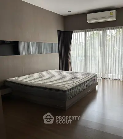 Spacious bedroom with large windows and natural light