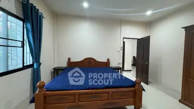 Spacious bedroom with elegant wooden bed and blue curtains, perfect for a cozy retreat.