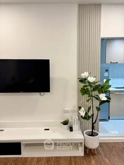 Modern living room with wall-mounted TV and stylish decor in a contemporary apartment.