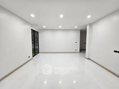 Spacious modern living room with white tiles and large windows
