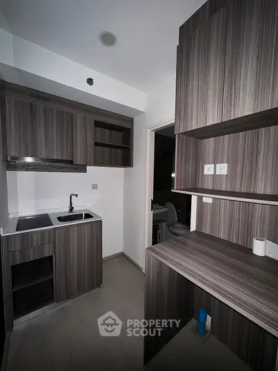 Modern compact kitchen with sleek cabinetry and integrated appliances