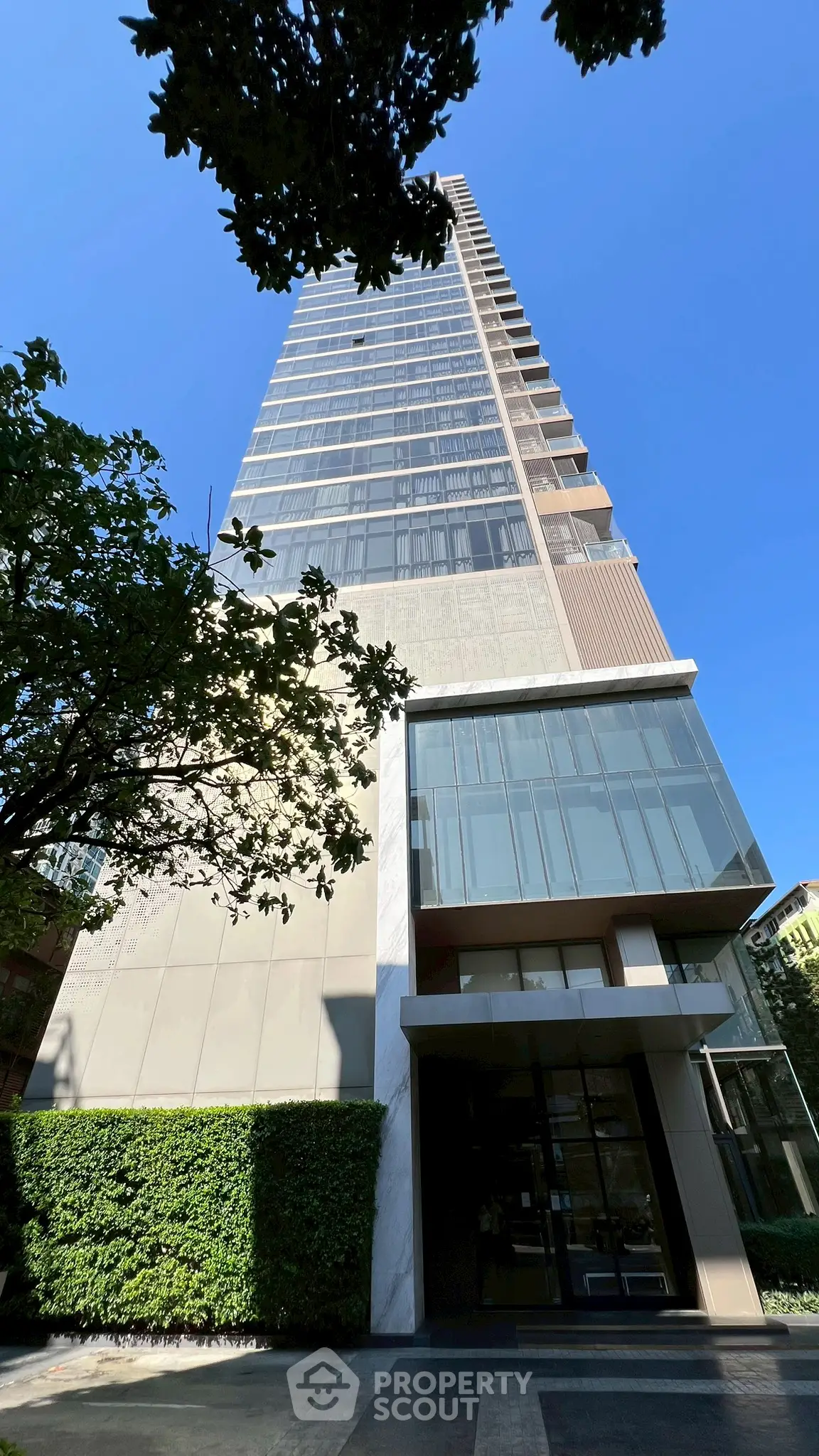 Stunning modern high-rise building with sleek glass facade and lush greenery