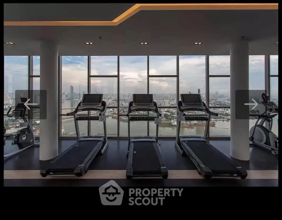 Luxurious gym with panoramic city view and modern fitness equipment in high-rise building.