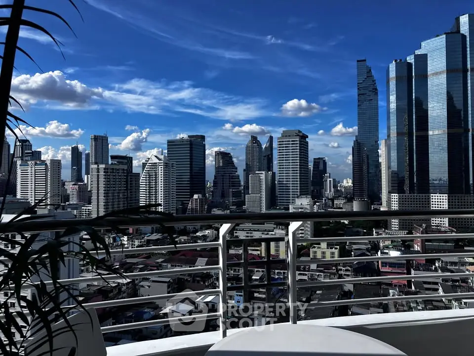 Stunning city skyline view from a modern balcony with clear blue skies.