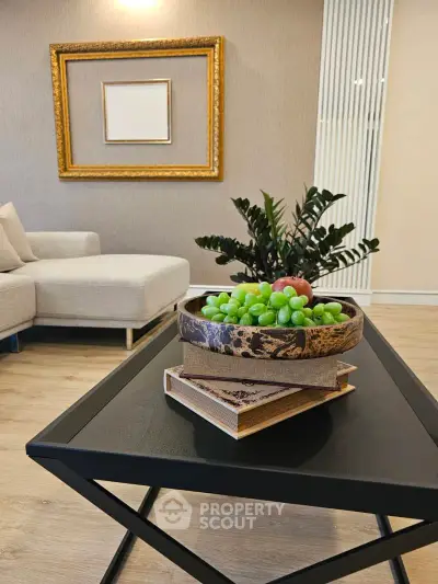 Stylish living room with modern decor, featuring a cozy sofa and elegant coffee table with fruit centerpiece.
