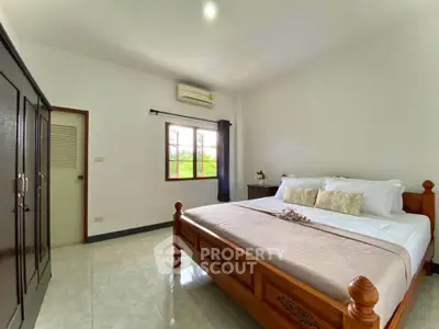Spacious bedroom with wooden bed frame and ample natural light