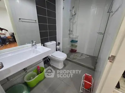 Modern bathroom with sleek design, featuring a glass shower enclosure and contemporary fixtures.