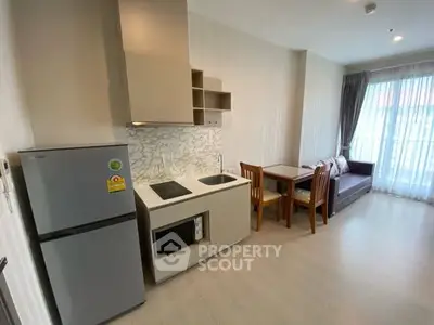 Modern studio apartment with compact kitchen and cozy dining area.
