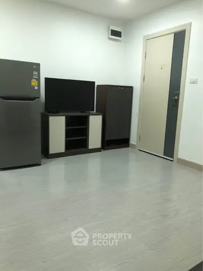 Modern minimalist living room with sleek TV stand and refrigerator